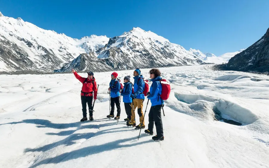 A guided group in crampons walking on the Tasman Glacier below Aoraki
