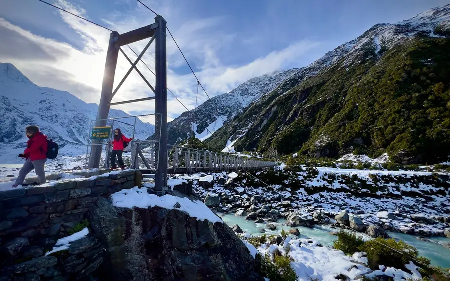 A walker crossing a swing bridge on the Hooker Valley Track